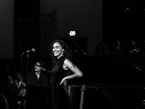 Wasia Project performing at Pico Union Project in Los Angeles, vocalist smiling on stage in a black dress beside a microphone stand with a pianist and guitarist visible behind her, in a black and white photo