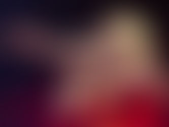 Ashe performing at Brooklyn Steel in New York City, smiling while singing into a microphone with one arm outstretched in a red satin dress under warm stage lighting