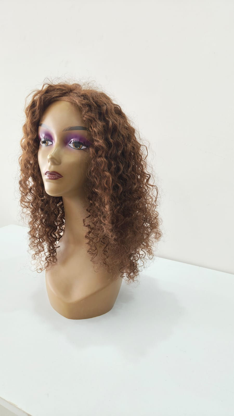 Eye-level view of a wig stand with a natural-colored wig