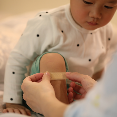 A child having a plaster put on their knee
