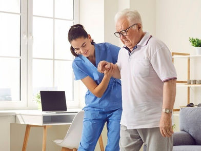 EHC Physiotherapist doing physiotherapy to improve the mobility of the elderly man at their home in Abu Dhabi.