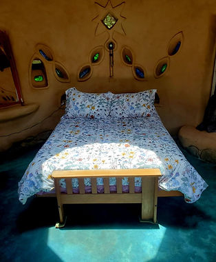 Cama doble de la Casita de Tierra con luz del tragaluz