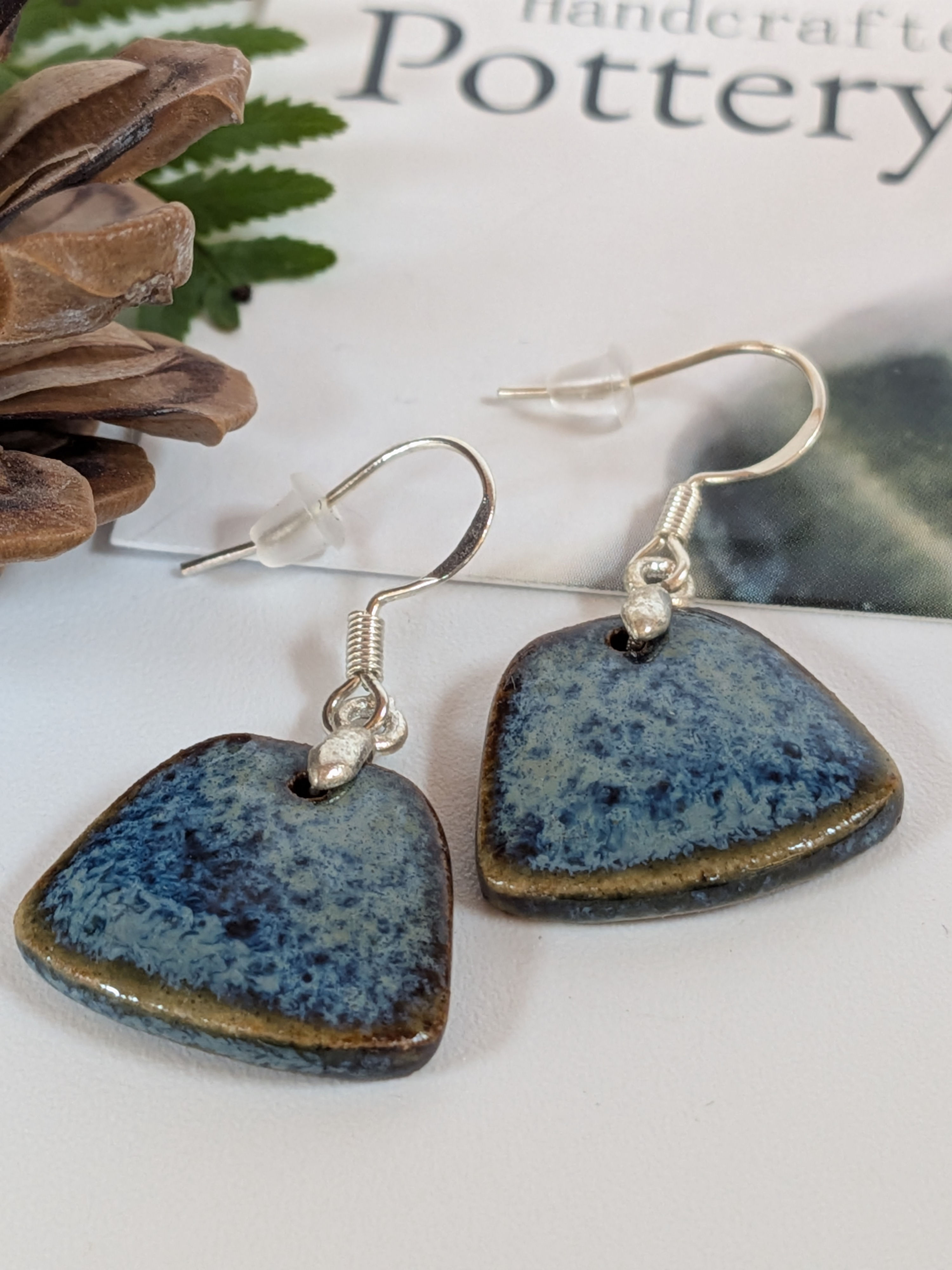 Deep blue and brown trapezoid pottery earrings on white background