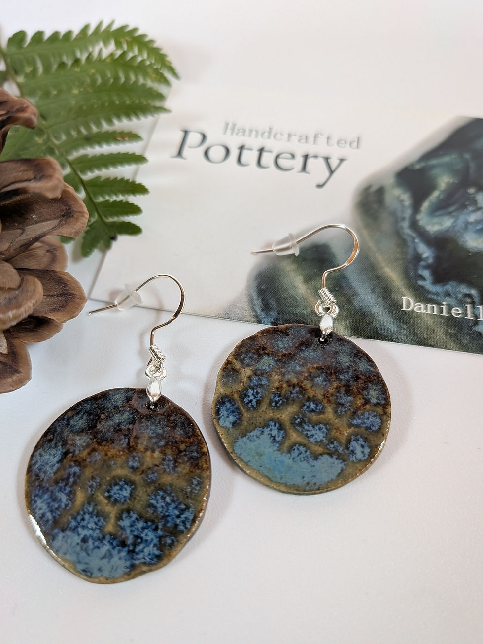 Thumbnail: Blue and brown autumn coloured hammered ceramic circle earring