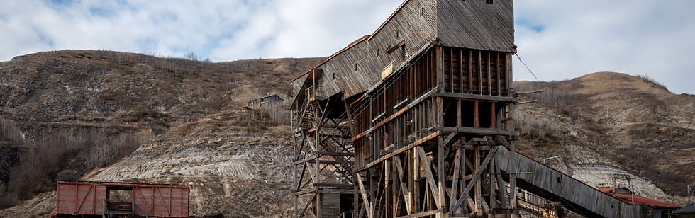 Historic wooden mining structure built into the side of a rocky hill in Alberta’s badlands, surrounded by sparse vegetation and rugged terrain. The image reflects Alberta’s industrial heritage and natural resource economy — aligning with KLV Accounting’s financial expertise in supporting mining operations and legacy businesses in Calgary and across the province.