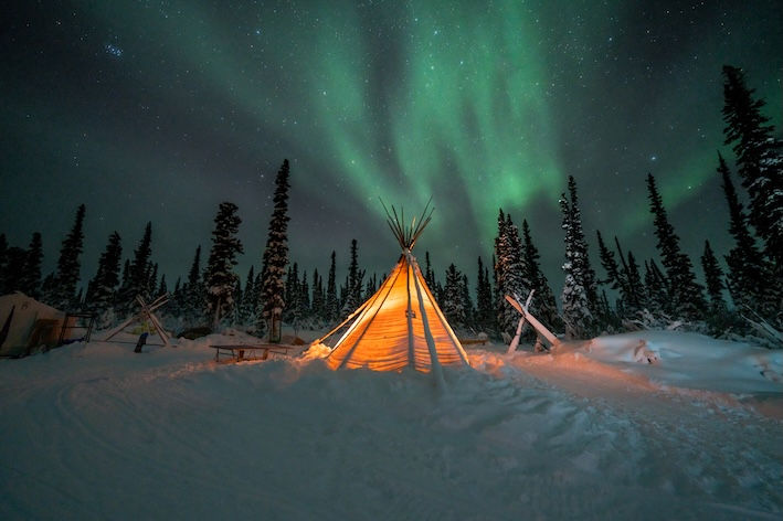Tipi in the snow with northern lights