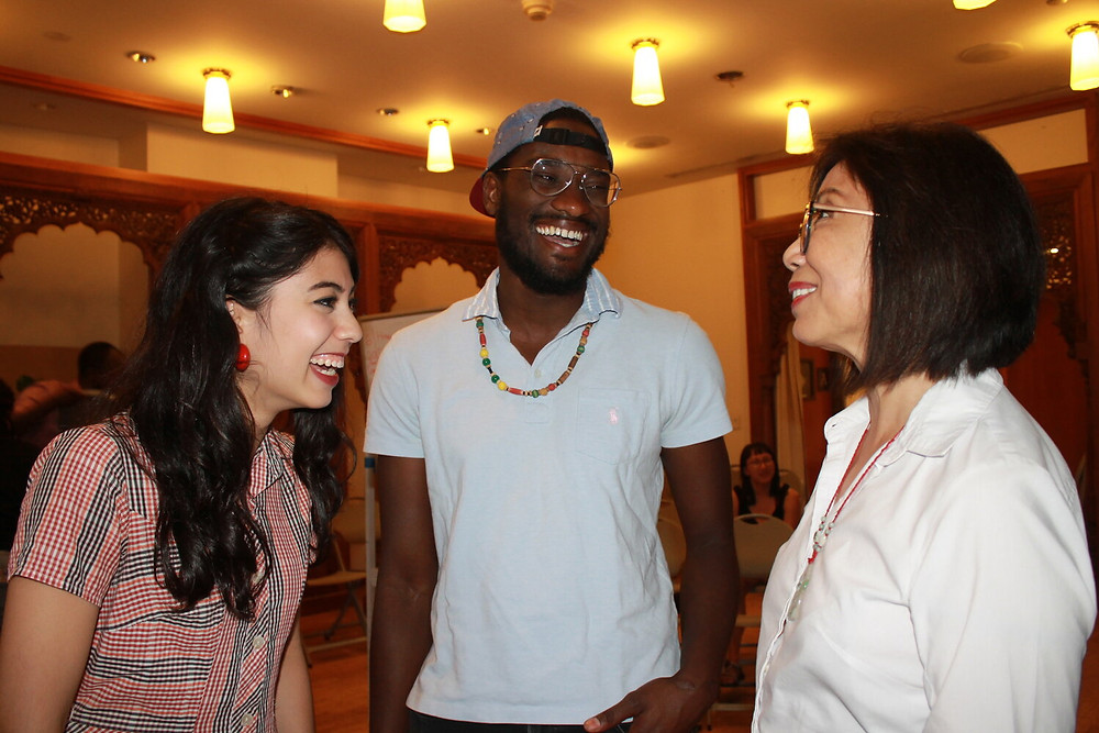 Photo from Ammud.org that shows three people smiling and laughing together. Yehudah is in the center of the image.