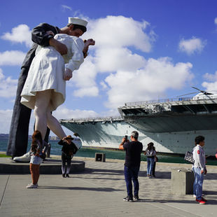 USS Midway aircraft carrier next to the statue of a sailor kissing a nurse
