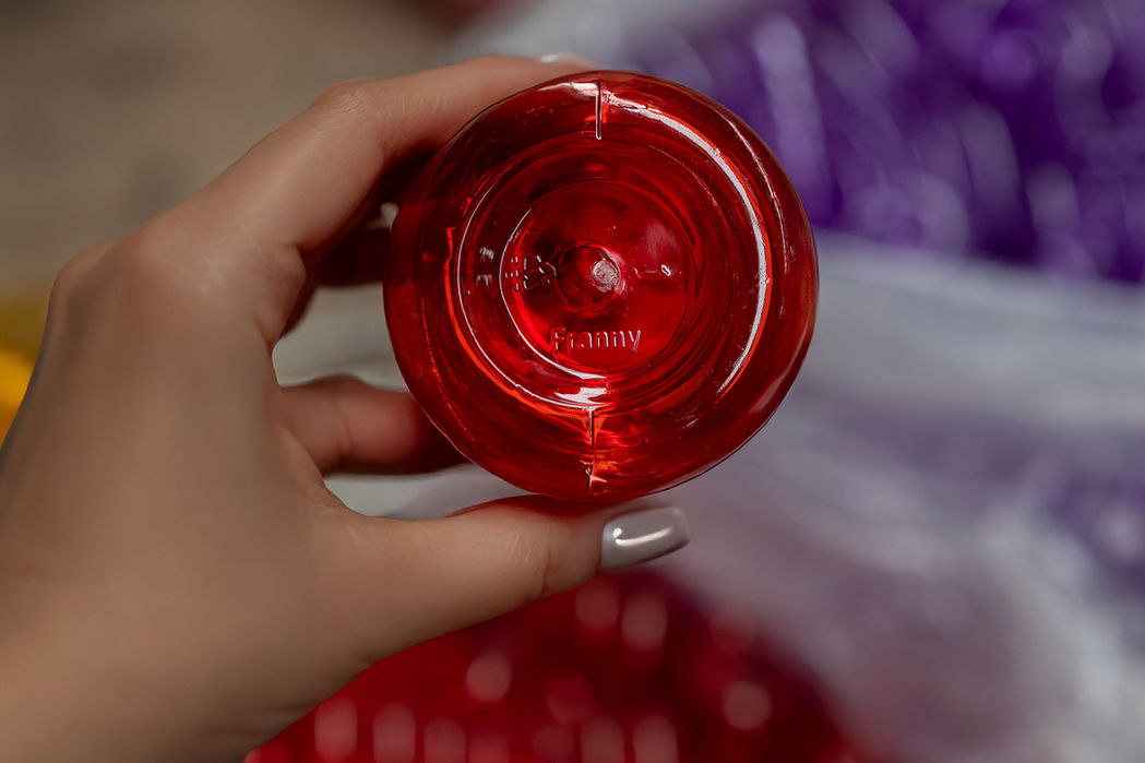 Mano sosteniendo componente rojo transparente de Alemania