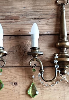 Fantástico par de apliques de origen francés de estilo Mid Century en latón macizo con un aro en la parte superior. Están en un estado de conservación maravilloso y han sido recableados recientemente. La luz que desprenden sus cristales se potencia por los dos caireles de color verde que cuelgan en las bases.