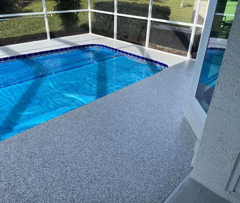 London Fog Flake Blend Pool Deck: Transform your pool deck with our London Fog flake blend epoxy flooring, featuring a blend of gray and white flakes that create a sophisticated and modern surface, perfect for enhancing the beauty and durability of your outdoor pool area.