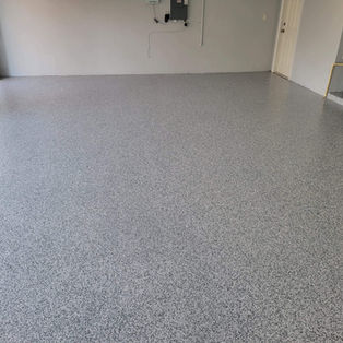 London Fog Flake Blend Garage Floor in Residential Setting: Transform your garage into a contemporary showcase with our London Fog flake blend, offering a stylish combination of gray and white flakes that elevate the overall appeal of your home's interior.