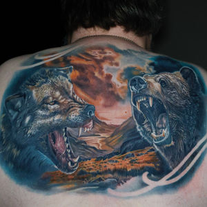 Colour back piece tattoo of a wolf and bear with a landscape background. Made in Llangefni, Isle of Anglesey, North Wales by Shelley Williams.