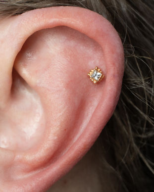 A helix cartilage piercing fitted with a beaded princess cut white sapphire from BVLA. Llangefni, Isle of Anglesey, North Wales.