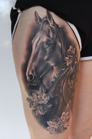 A black and grey portrait tattoo of the clients horses on a leg. Made in Llangefni, Isle of Anglesey, North Wales by Shelley Williams.