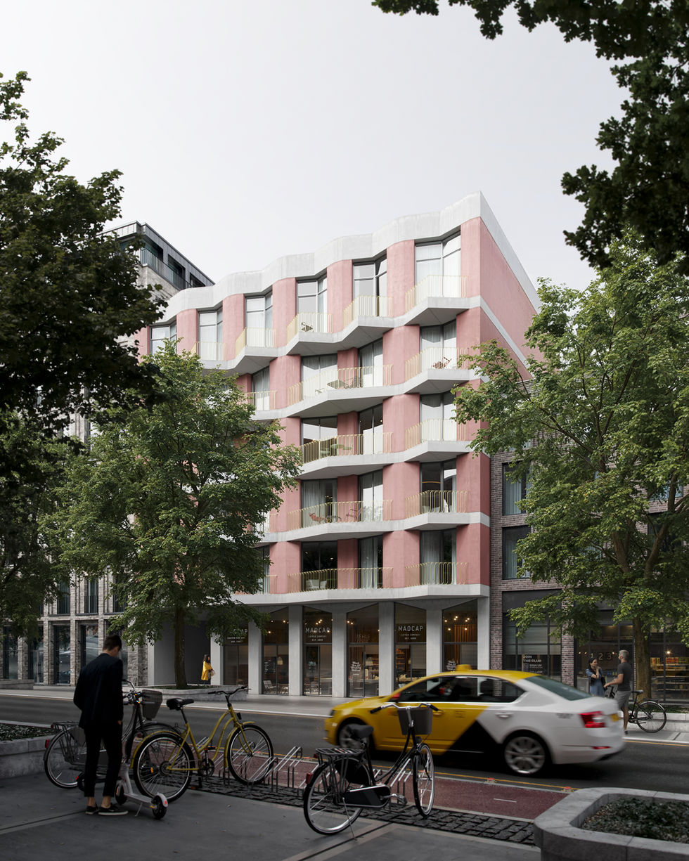 Street-level view of  coral pink mid-rise residential building with cafe and yellow taxi