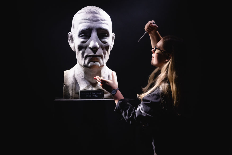 Sculpture of William Burroughs, voiced by Jason Isaacs, and Gabriella Moran in Lost Watches (2025)