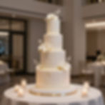 Four-tier white cake in a luxury wedding gallery.