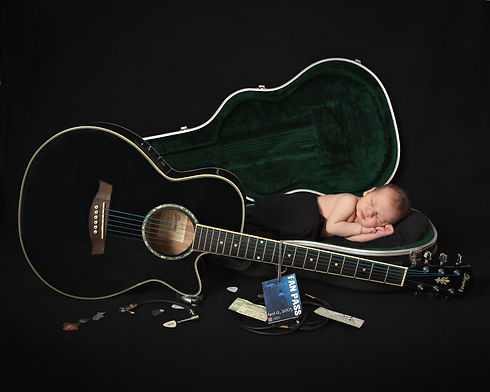 newborn baby boy laying in a guitar case