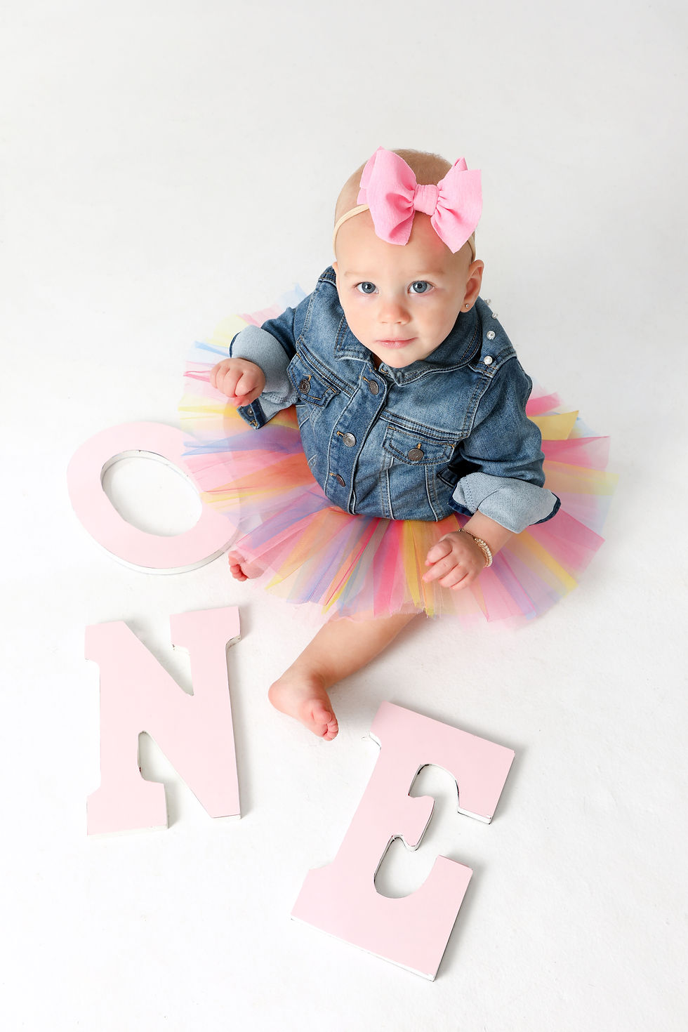 little girl in denim jacket with one letters