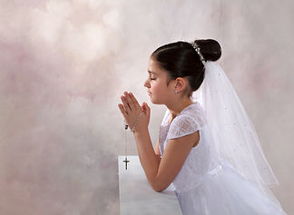 communion girl in profile praying with rosary beads