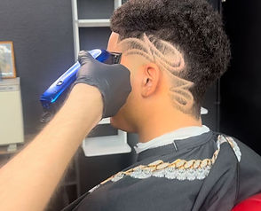 Barber shaping a stylish haircut on a client with clippers