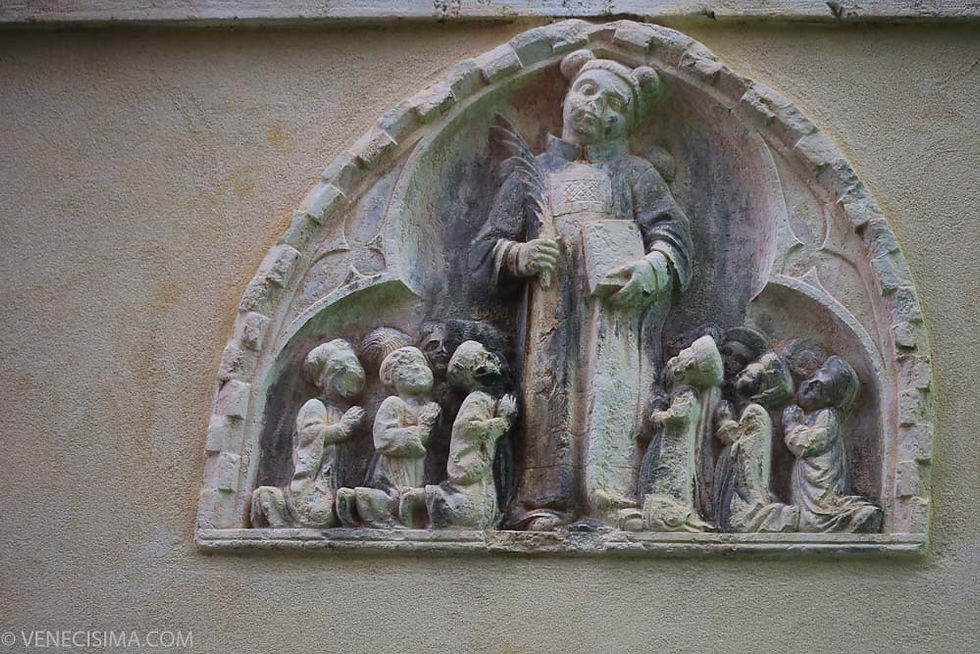 Bajorrelieve gótico (siglo XV) en la fachada que representa a San Esteban adorado por sus hermanos.