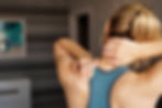 Sports injury concept. Athletic woman feeling pain in her neck against blurred background.