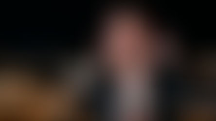 White woman with short hair outside with silent disco headphones on.