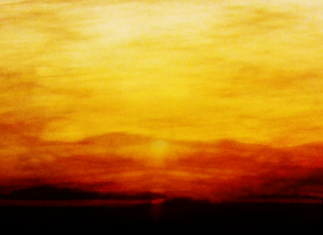 Orange and yellow sunset with the sun visible on the horizon