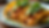 Close-up view of shrimp tacos garnished with avocado and cilantro