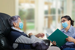 An everyday female caregiver reads books for an elderly woman. The corona-virus pandemic h
