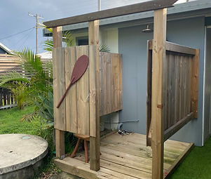 wooden outdoor shower with rustic oar on the side of the enclosed walls