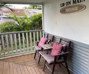 wooden front deck with two seats and side table