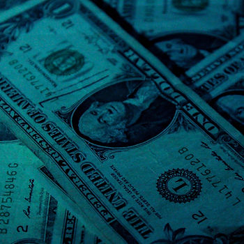Blue-tinted dollars, casting shadows to convey an aura of secrecy and clandestine dealings.