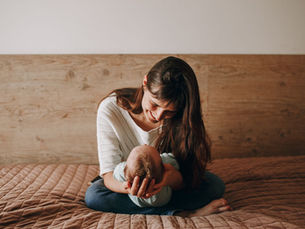 Woman holding baby on a bed
