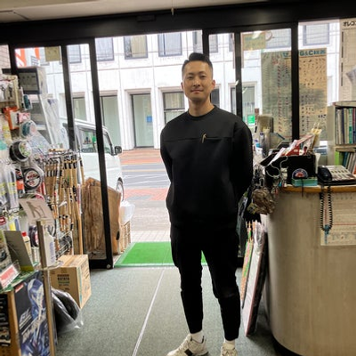 alt="中屋金物店の店主 田中雄大 笑顔で迎える店内の様子"