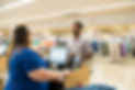 Goodwill employee at the register chatting with a customer while processing their purchase.
