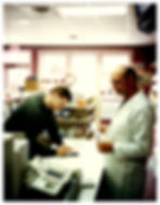 Pat Chitmon (right), pharmacist and original owner of Super V Drugs,ringing up a prescription for a patient