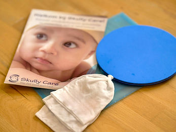 The Skully Care Toolkit displayed with its three components: a beanie, a mat, and an informational flyer.