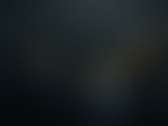 A person walks through a dimly lit maze of transparent walls, casting soft shadows. The atmosphere is mysterious and moody.