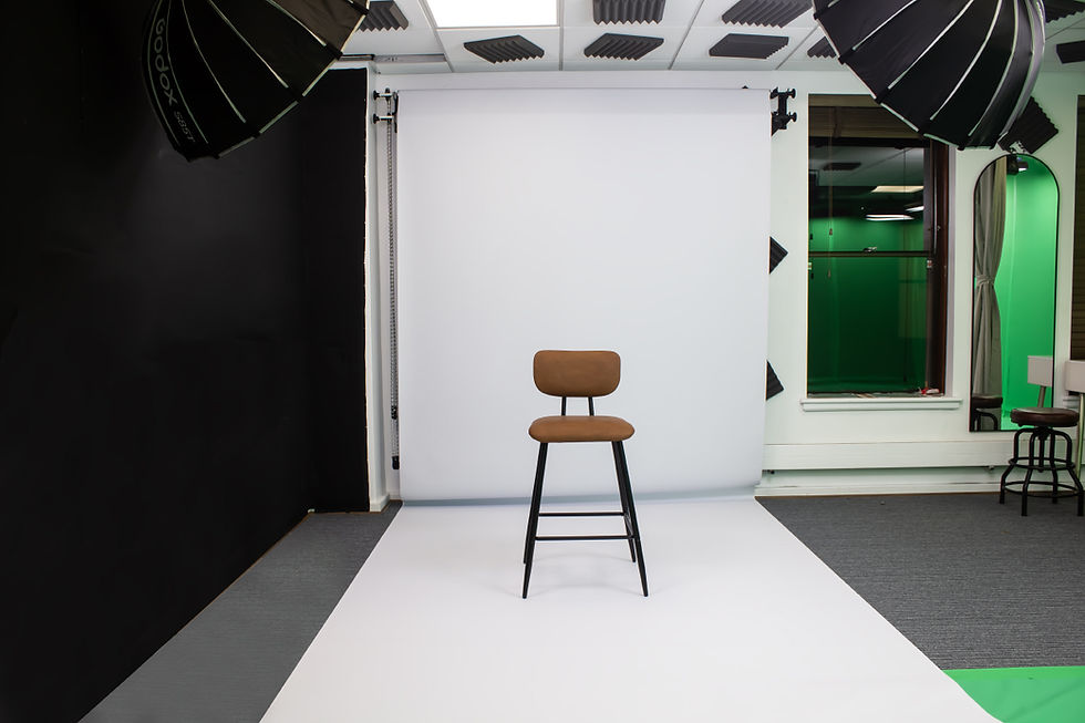 Eye-level view of a spacious photography studio with white walls and professional lighting