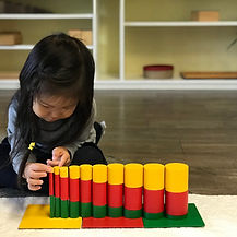 Montessori student working on stacking blocks to reinforce math concepts and tactile skills at La Jolla Village Montessori