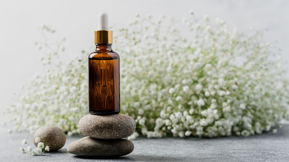 Facial serum balanced on pebbles with flowers in the background
