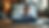 Smiling man on a laptop video call in a cozy home office, with a lamp, window plants, and warm light.