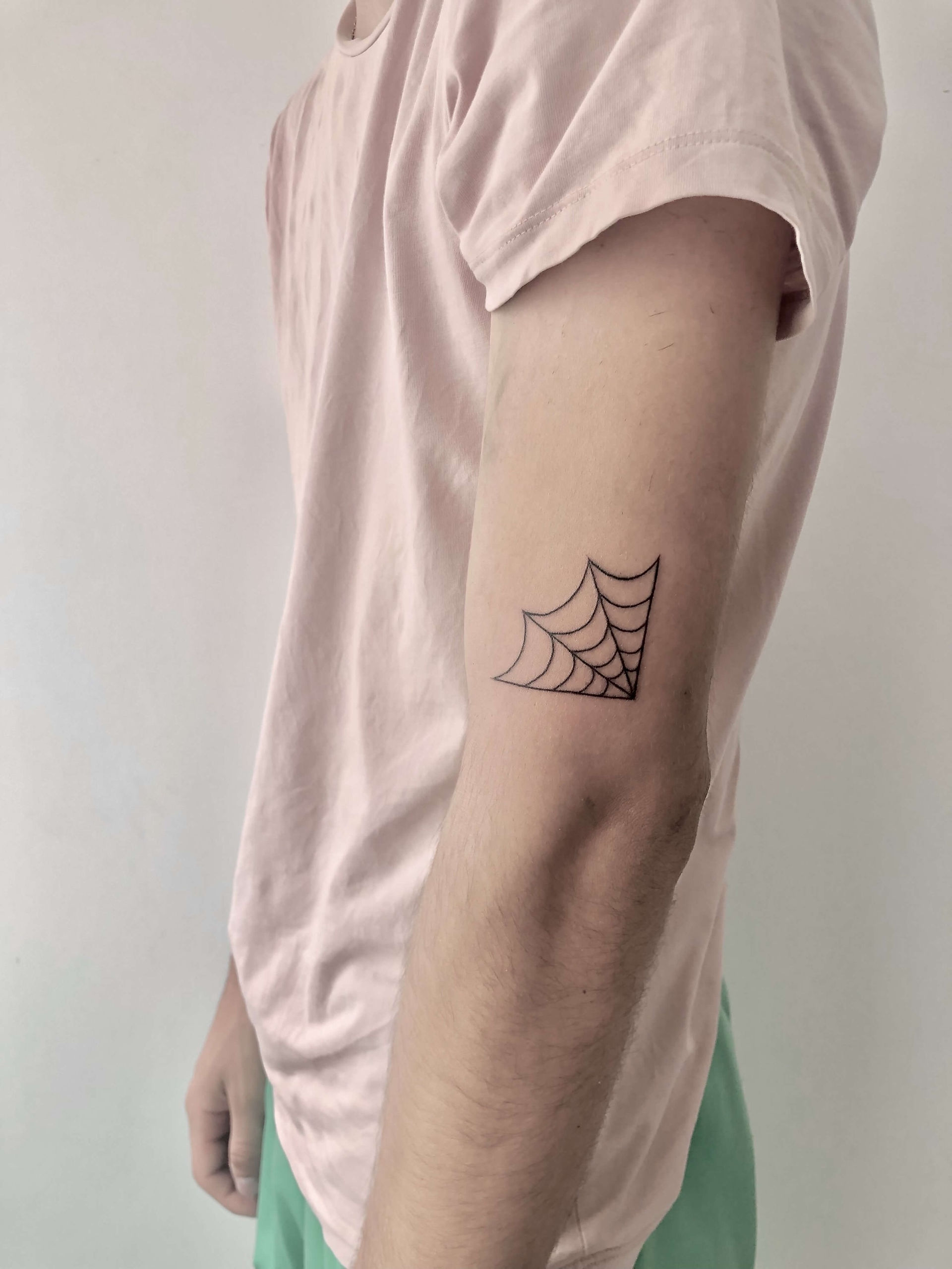 tatouage fin et minimaliste d'une toile d' araignée sur le coude fait à bordeaux en gironde