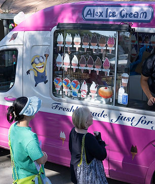 Alex ice cream truck serving ice cream to customers on a sunny day.