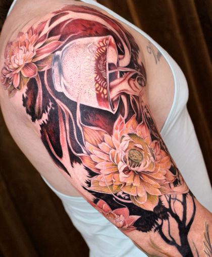 A half sleeve tattoo of a teacup pouring magical liquid out along with two white lotus flowers. The teacup and white lotus represents Uncle Iroh from Avatar: The Last Airbender