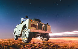 Land Rover and starry sky at night in the desert of Dubai - UAE.