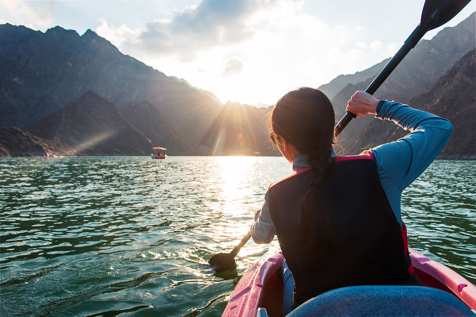 Woman kayaking in scenic Hatta lake in Dubai at sunset